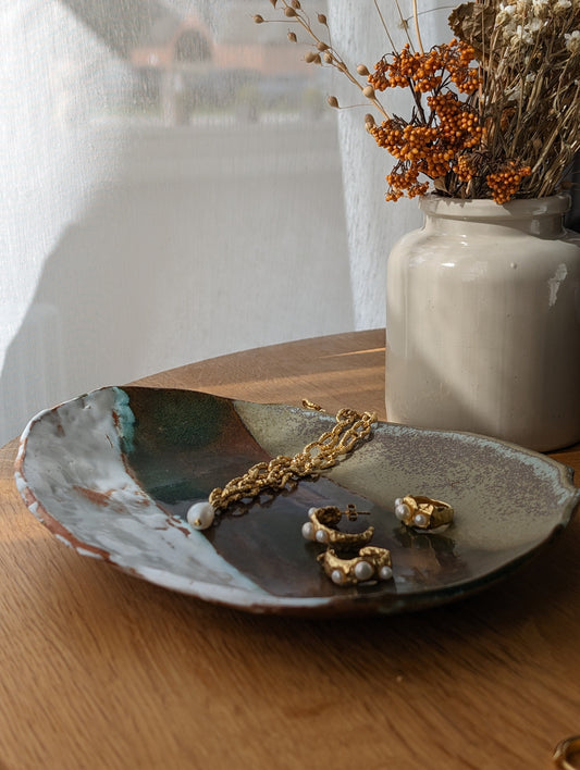 Pieces of Another Mother jewellery on a dark navy plate